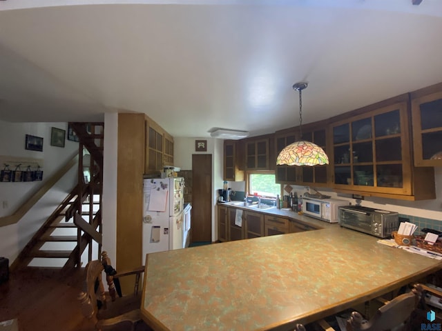 1496 121st St, Luverne, MN 56156 - kitchen with white appliances, glass insert cabinets, a peninsula, and decorative light fixtures