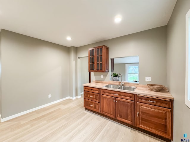 340 N Juniper Ave, Parker, SD 57053 - kitchen featuring glass insert cabinets, light wood-style floors, light countertops, brown cabinets, and recessed lighting