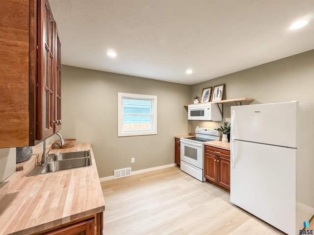 340 N Juniper Ave, Parker, SD 57053 - kitchen with white appliances, light wood-style floors, recessed lighting, brown cabinets, and butcher block counters