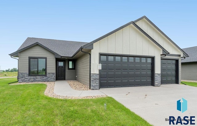 1201 E Wayne Pl, Tea, SD 57064 - view of front facade with an attached garage, stone siding, board and batten siding, driveway, and a front lawn