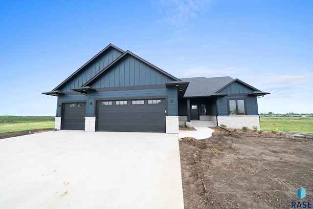 5601 E Morningside Cir, Sioux Falls, SD 57110 - view of front facade featuring board and batten siding, an attached garage, concrete driveway, and stone siding