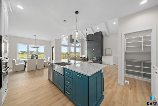 5601 E Morningside Cir, Sioux Falls, SD 57110 - kitchen with a chandelier, blue cabinets, stainless steel appliances, light wood-type flooring, and pendant lighting