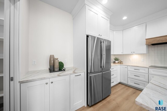 5601 E Morningside Cir, Sioux Falls, SD 57110 - kitchen featuring freestanding refrigerator, light wood-style flooring, white cabinets, decorative backsplash, and light stone countertops
