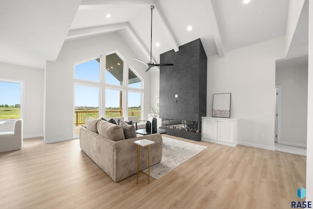 5601 E Morningside Cir, Sioux Falls, SD 57110 - living area with high vaulted ceiling, beam ceiling, light wood-style floors, a ceiling fan, and a tiled fireplace