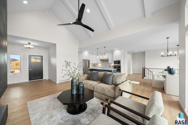 5601 E Morningside Cir, Sioux Falls, SD 57110 - living room featuring light wood-type flooring, ceiling fan, high vaulted ceiling, a chandelier, and beamed ceiling
