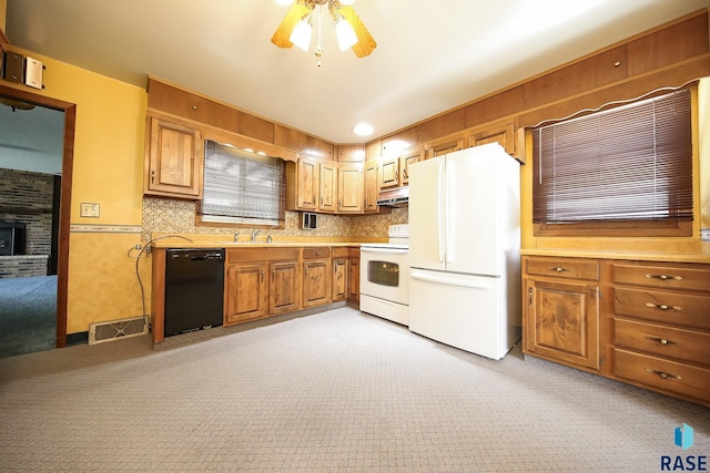 2312 E 19th St, Sioux Falls, SD 57103 - kitchen featuring white appliances, light colored carpet, light countertops, ceiling fan, and under cabinet range hood