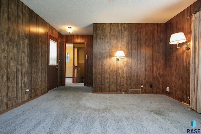 2312 E 19th St, Sioux Falls, SD 57103 - unfurnished room featuring carpet, wood walls, and a textured ceiling