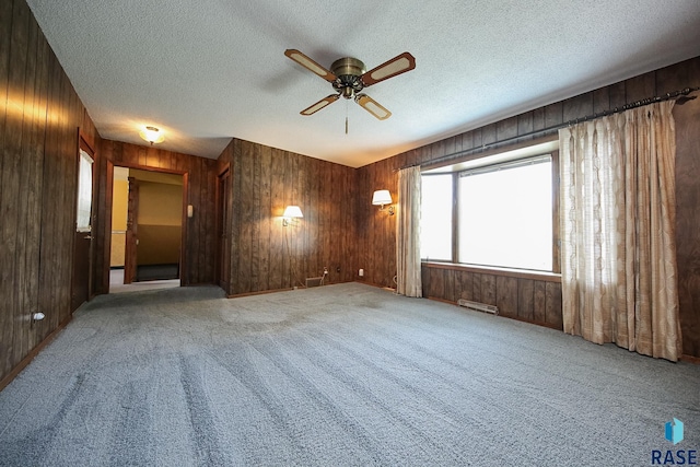2312 E 19th St, Sioux Falls, SD 57103 - empty room featuring wood walls, a ceiling fan, carpet floors, and a textured ceiling