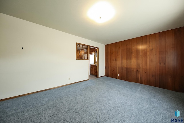 2312 E 19th St, Sioux Falls, SD 57103 - carpeted empty room featuring wood walls and baseboards