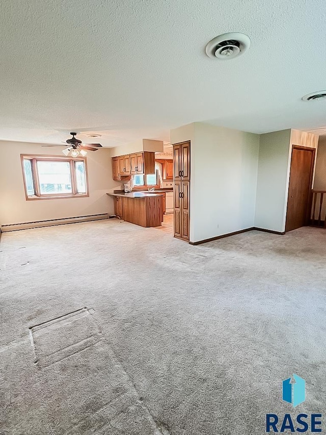 515 151st St, Luverne, MN 56156 - unfurnished living room with a baseboard heating unit, a textured ceiling, light colored carpet, and ceiling fan