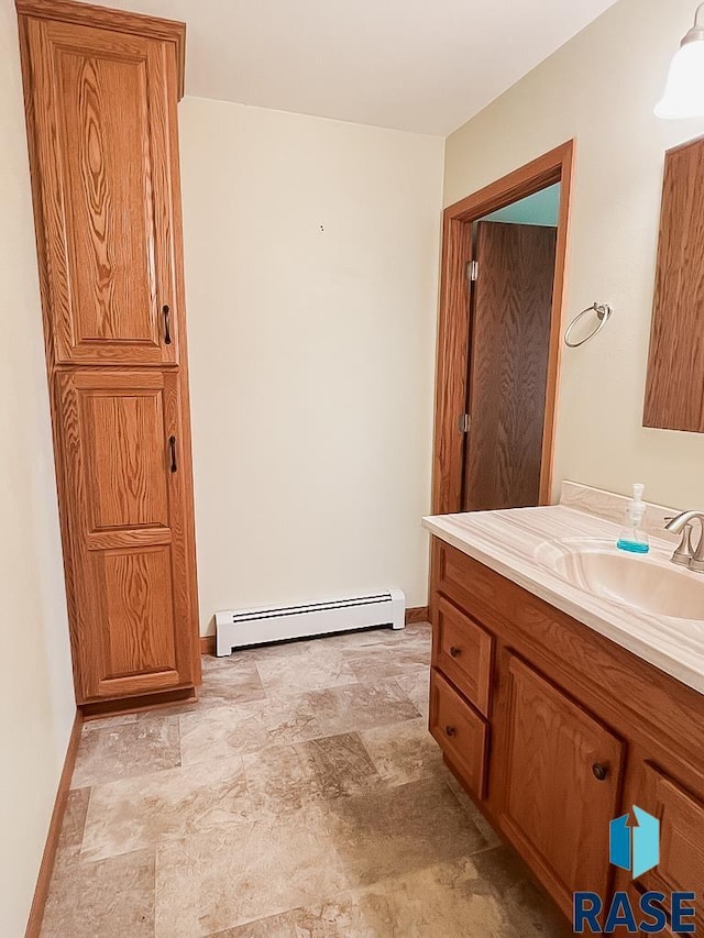 515 151st St, Luverne, MN 56156 - bathroom featuring baseboard heating, stone finish floors, and vanity