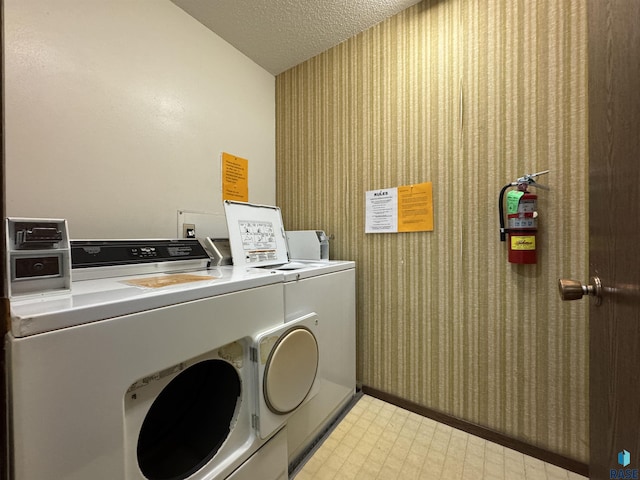 3552 S Gateway Blvd Unit 204, Sioux Falls, SD 57106 - washroom with washing machine and clothes dryer, wallpapered walls, a textured ceiling, and light flooring