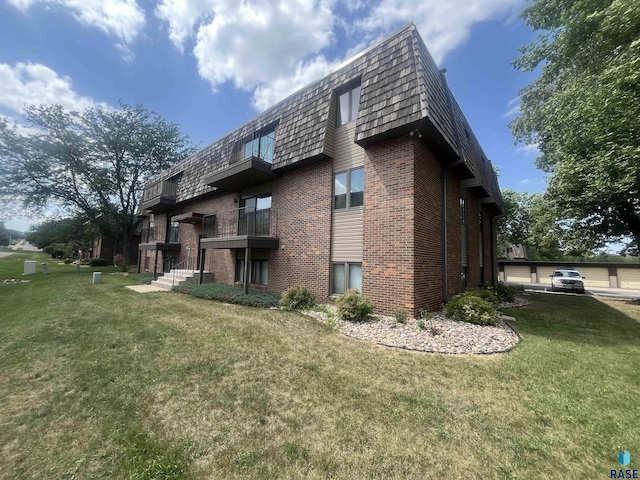 3552 S Gateway Blvd Unit 204, Sioux Falls, SD 57106 - rear view of property featuring mansard roof, brick siding, and a lawn