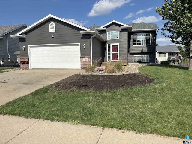 5312 S Leinster Ave, Sioux Falls, SD 57106 - view of front facade featuring an attached garage, concrete driveway, a front yard, and brick siding