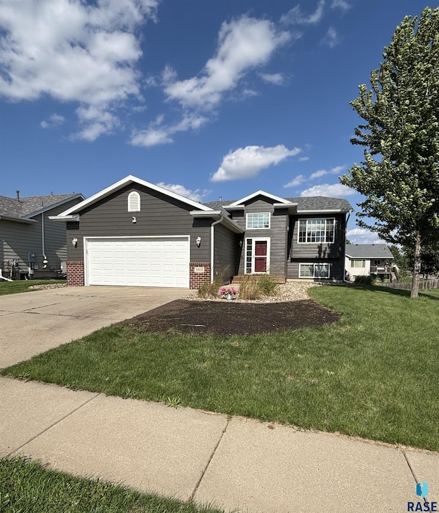 5312 S Leinster Ave, Sioux Falls, SD 57106 - view of front of home with an attached garage, concrete driveway, a front lawn, and brick siding