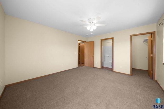 1418 E Redwood Blvd, Brandon, SD 57005 - unfurnished bedroom featuring a walk in closet, light colored carpet, a ceiling fan, a closet, and ensuite bath