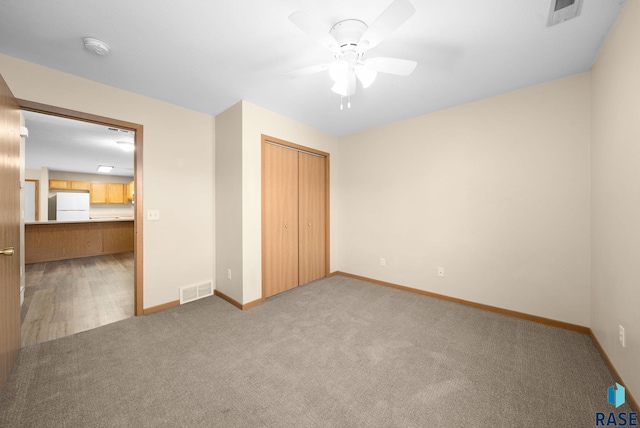 1418 E Redwood Blvd, Brandon, SD 57005 - unfurnished bedroom featuring freestanding refrigerator, carpet flooring, a closet, and ceiling fan