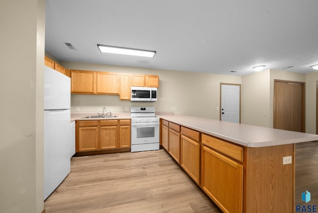 1418 E Redwood Blvd, Brandon, SD 57005 - kitchen with white appliances, a peninsula, light wood-type flooring, and light countertops