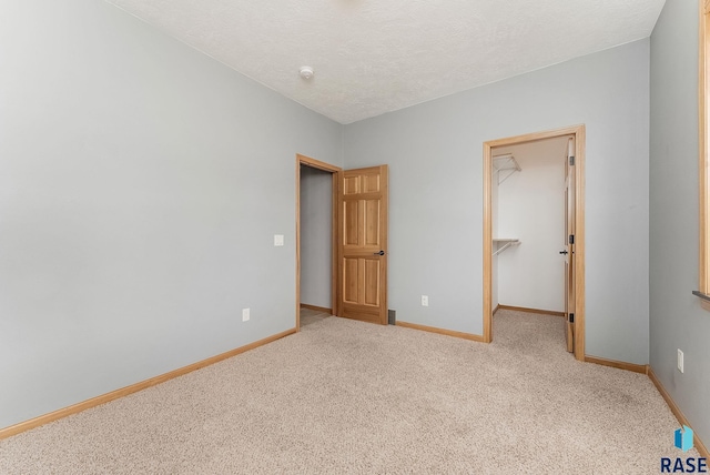 635 E Brian St, Tea, SD 57064 - unfurnished bedroom with carpet, a walk in closet, a textured ceiling, and a closet