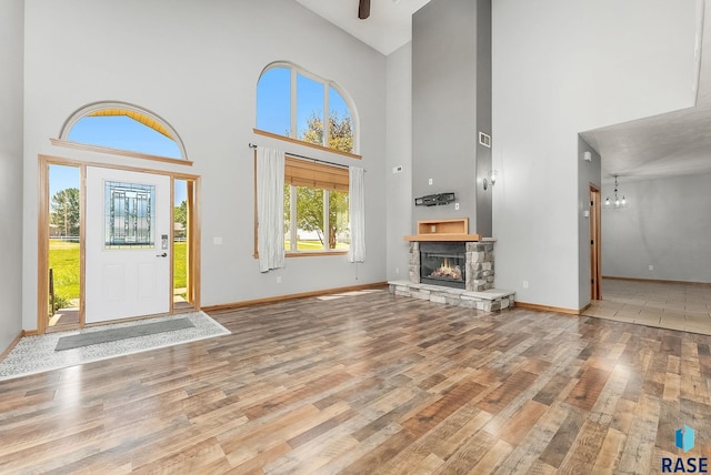 635 E Brian St, Tea, SD 57064 - foyer with high vaulted ceiling, wood finished floors, a stone fireplace, and a chandelier