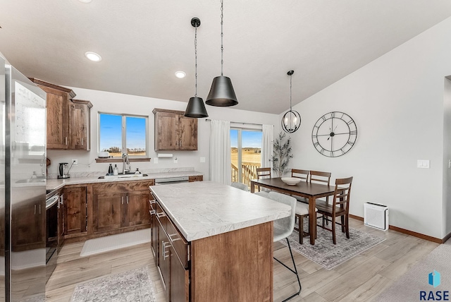 9400 W Colton St, Sioux Falls, SD 57106 - kitchen with appliances with stainless steel finishes, light wood-style flooring, a kitchen bar, a center island, and light countertops