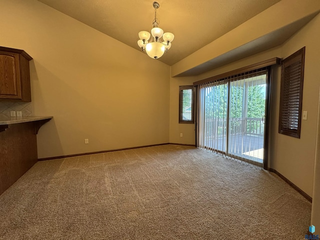 3908 W 89th St, Sioux Falls, SD 57108 - unfurnished dining area with a chandelier, carpet floors, and vaulted ceiling