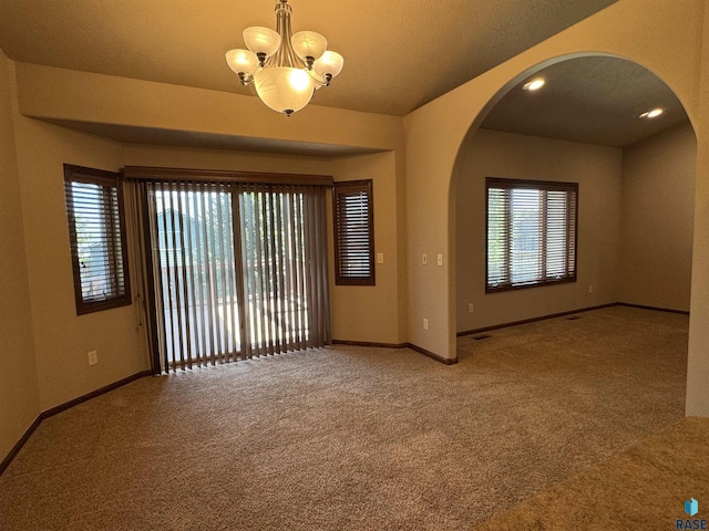 3908 W 89th St, Sioux Falls, SD 57108 - unfurnished room with carpet floors, arched walkways, and a chandelier