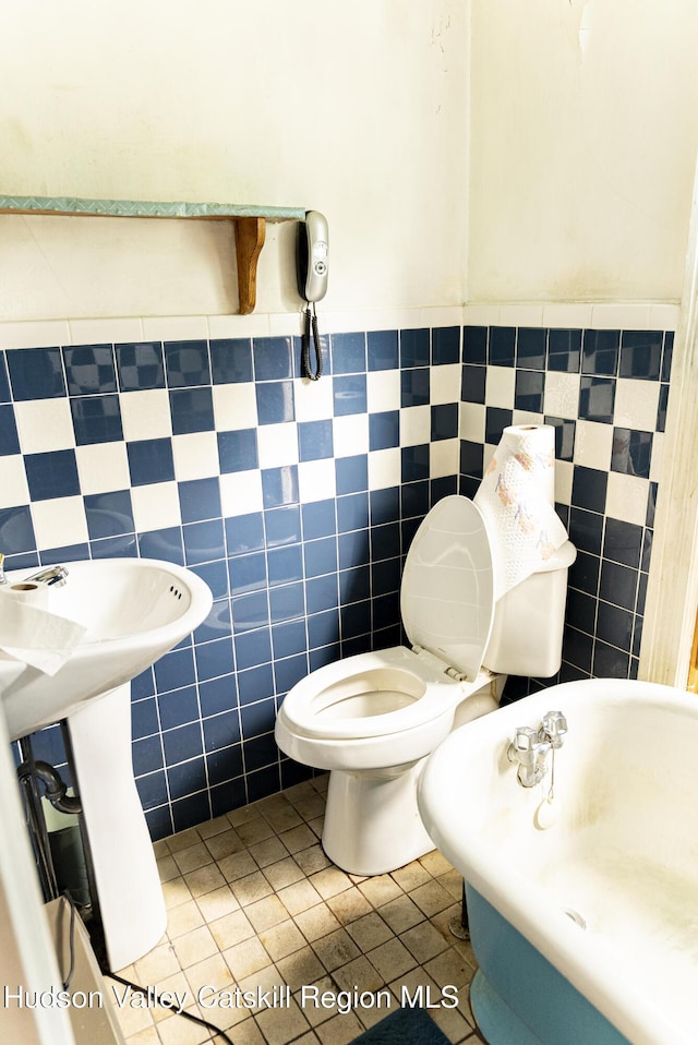 53 Broad St, Catskill, NY 12414 - bathroom featuring wainscoting, tile patterned floors, tile walls, and a bathtub