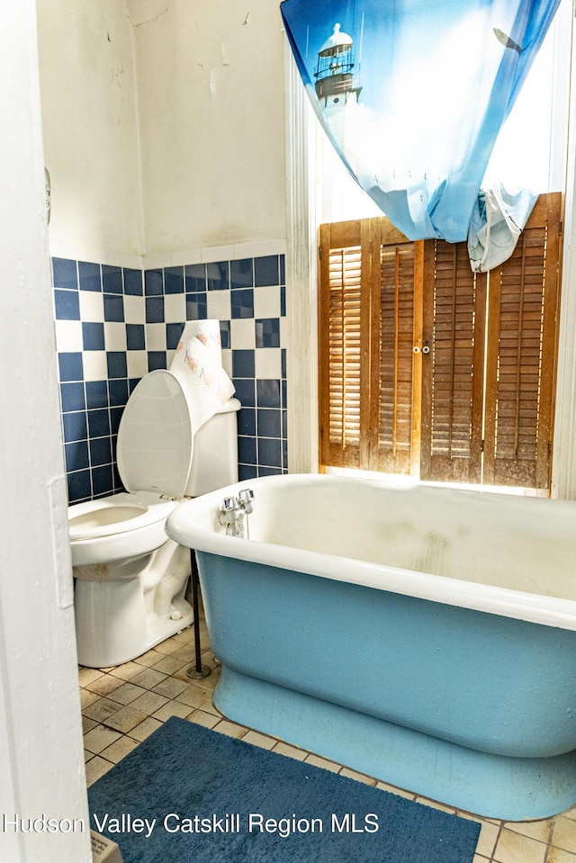 53 Broad St, Catskill, NY 12414 - full bathroom with a freestanding bath, tile patterned floors, wainscoting, and tile walls