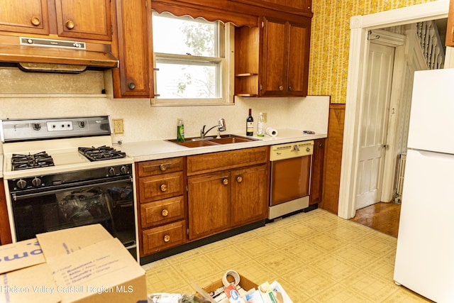 53 Broad St, Catskill, NY 12414 - kitchen with freestanding refrigerator, range with gas stovetop, dishwashing machine, under cabinet range hood, and wallpapered walls