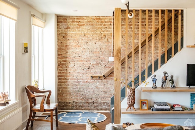 705 Warren St, Hudson, NY 12534 - staircase featuring brick wall, radiator heating unit, and wood finished floors