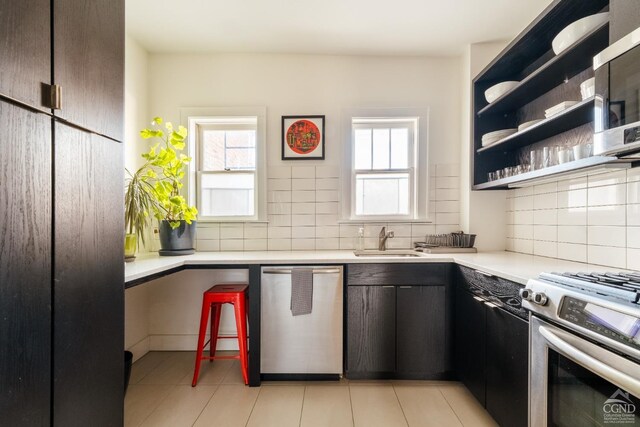 705 Warren St, Hudson, NY 12534 - kitchen with appliances with stainless steel finishes, a sink, decorative backsplash, and light countertops