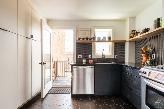 705 Warren St, Hudson, NY 12534 - kitchen featuring stainless steel appliances, open shelves, dark countertops, a sink, and tasteful backsplash