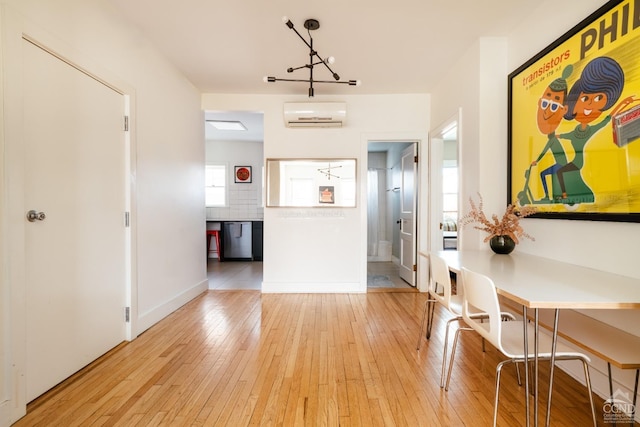 705 Warren St, Hudson, NY 12534 - dining area featuring a wall unit AC, light wood-style flooring, and baseboards