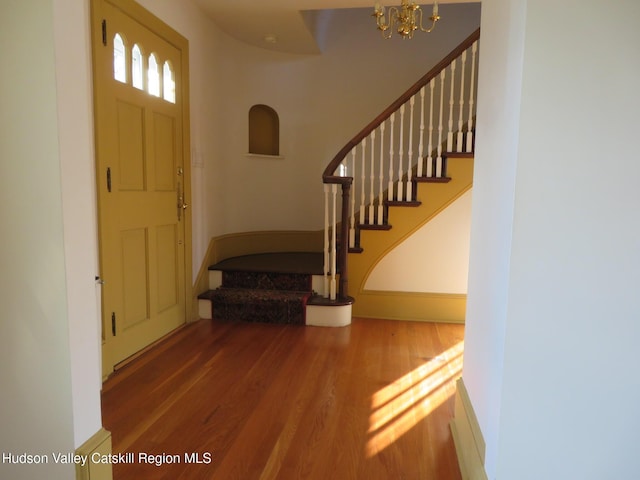 foyer with hardwood / wood-style floors and an inviting chandelier