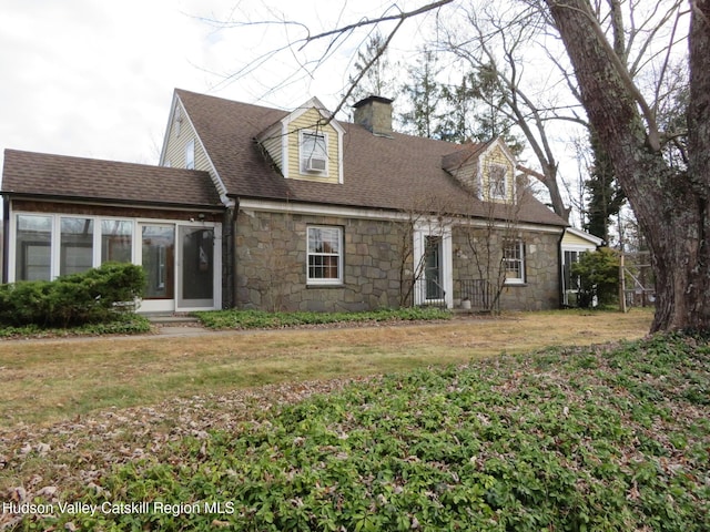 rear view of house with a lawn and a sunroom