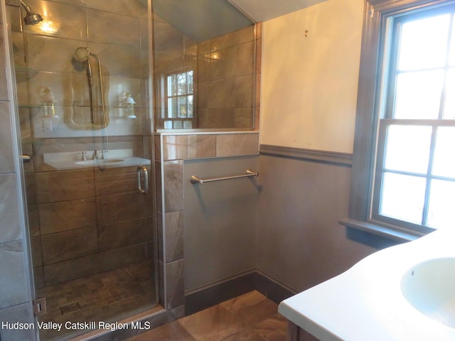 bathroom featuring vanity and a shower with door