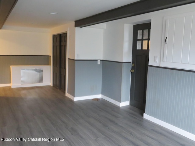 spare room with beam ceiling and hardwood / wood-style flooring