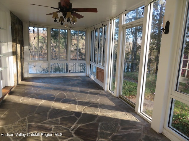 unfurnished sunroom with ceiling fan