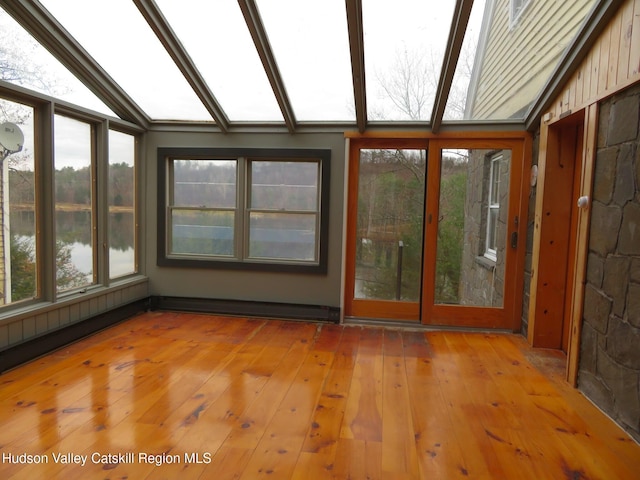 unfurnished sunroom with a water view, vaulted ceiling, and a baseboard heating unit