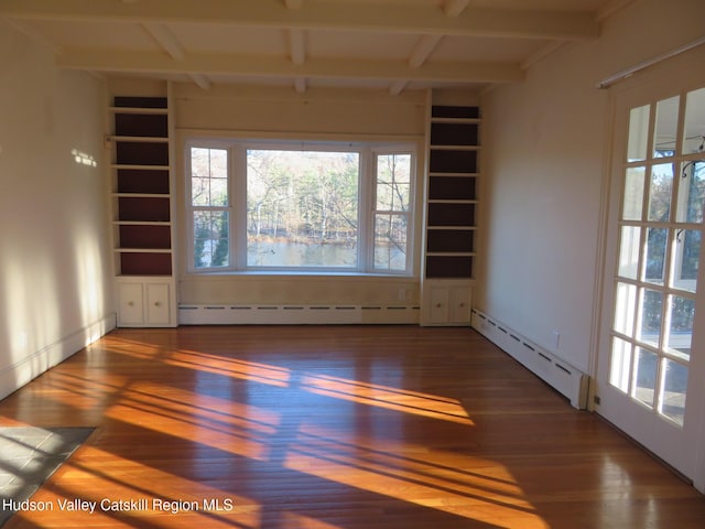 spare room featuring baseboard heating, dark hardwood / wood-style flooring, and beamed ceiling