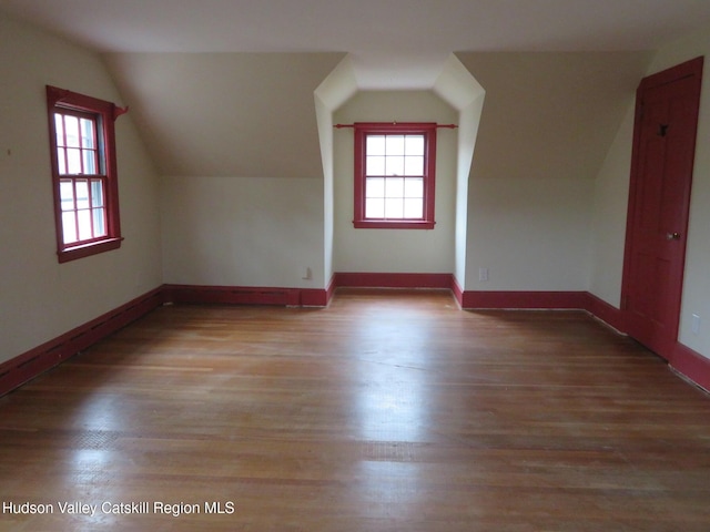 bonus room with light hardwood / wood-style flooring and lofted ceiling