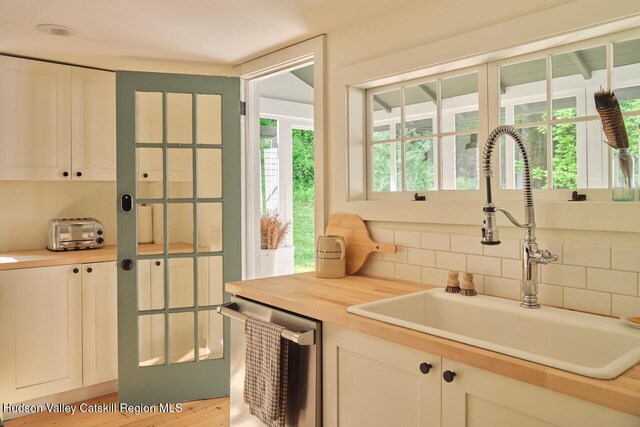 1556 Gulf Rd, Callicoon Center, NY 12724 - kitchen with dishwasher, backsplash, and white cabinetry