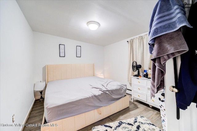 bedroom featuring baseboards and wood finished floors