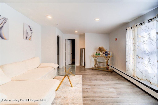 living room with light wood-style flooring, baseboards, baseboard heating, and recessed lighting