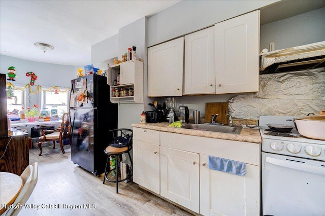 kitchen featuring white range, a sink, light countertops, freestanding refrigerator, and open shelves