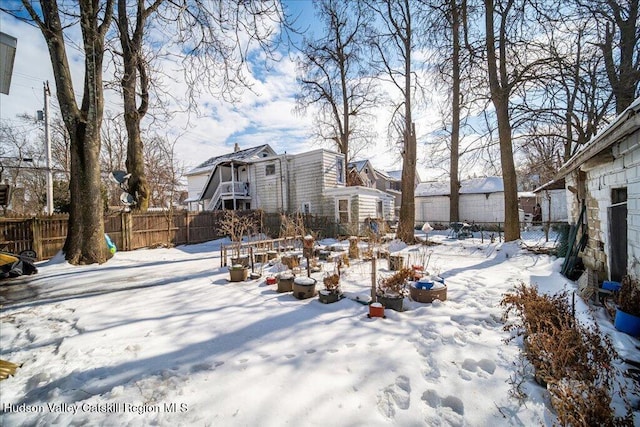 yard covered in snow with a fenced backyard