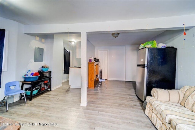 living room featuring light wood finished floors, electric panel, and baseboards
