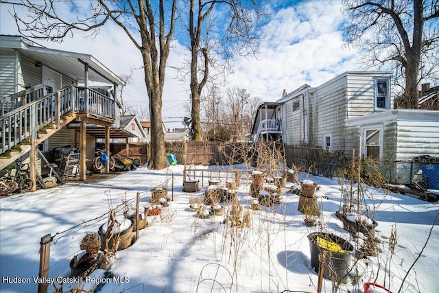 yard covered in snow with stairs and fence