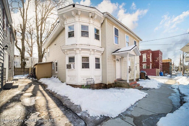 italianate house featuring fence and cooling unit